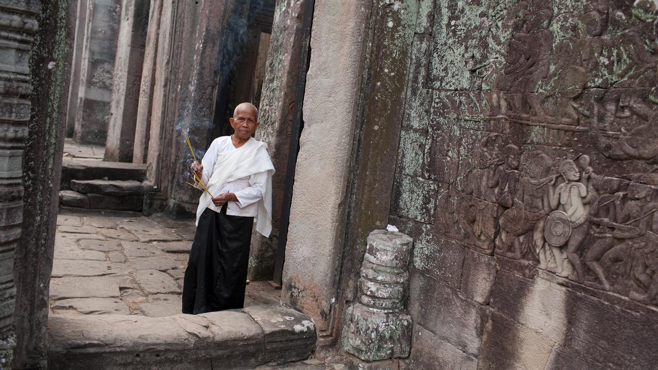 Khmer woman walking through a remote Cambodian temples