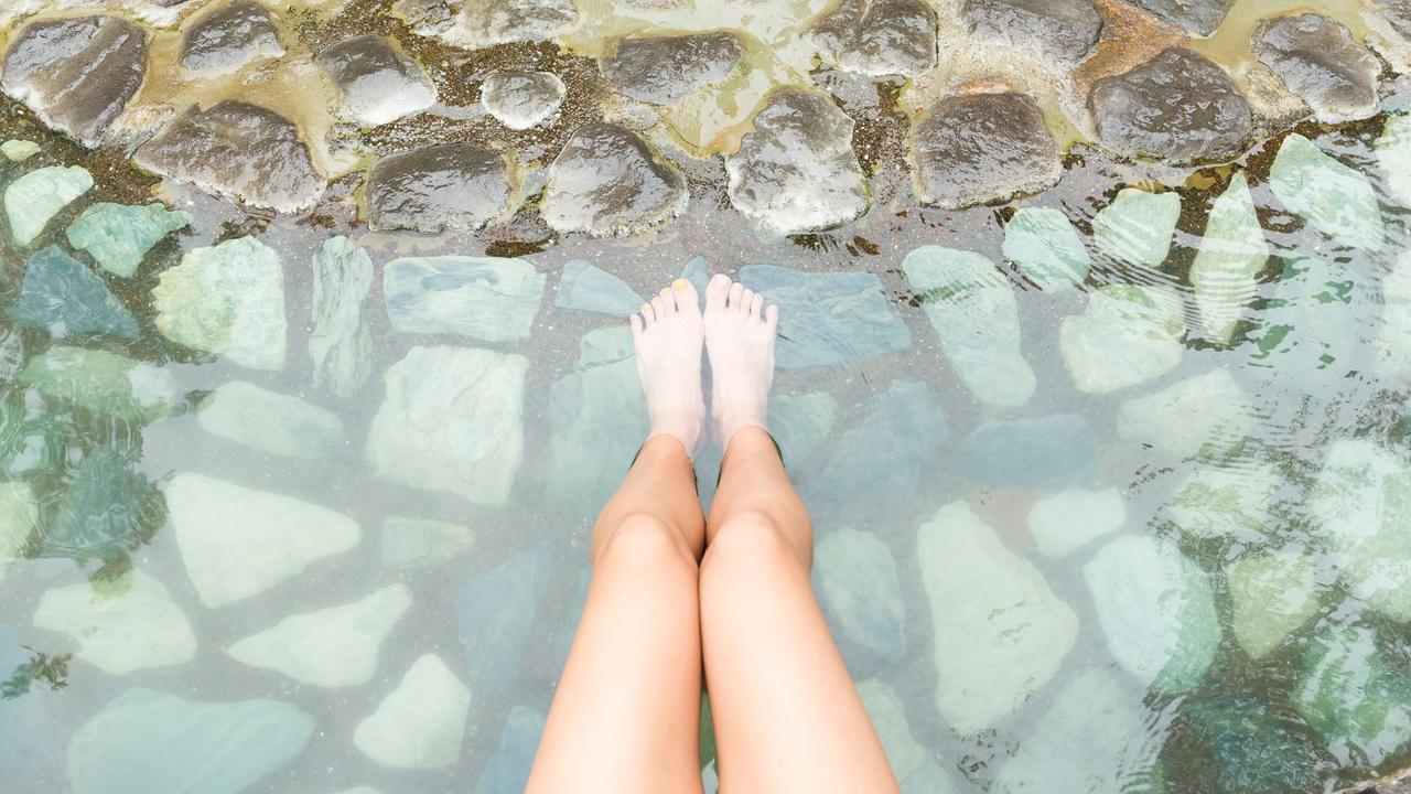 A pair of legs soaking in hot spring waters in Japan. Selective Asia.