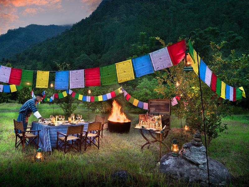 Al fresco dining under prayer flags at and Beyond Punakha River Lodge